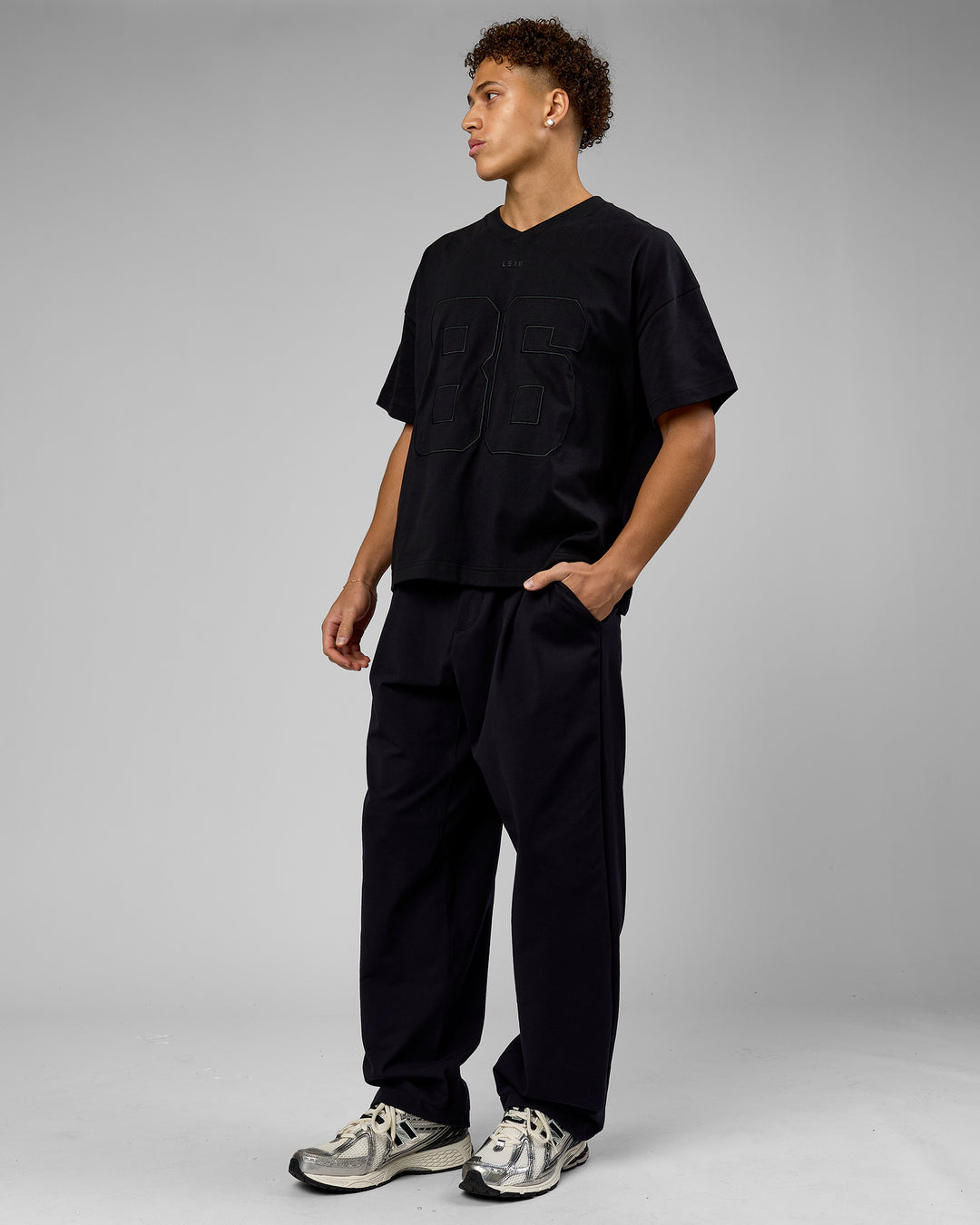 Man wearing 86 V-Neck Oversized Tee - Black-Black | Model:Leandro | Size:M
