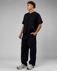 Man wearing 86 V-Neck Oversized Tee - Black-Black | Model:Leandro | Size:M