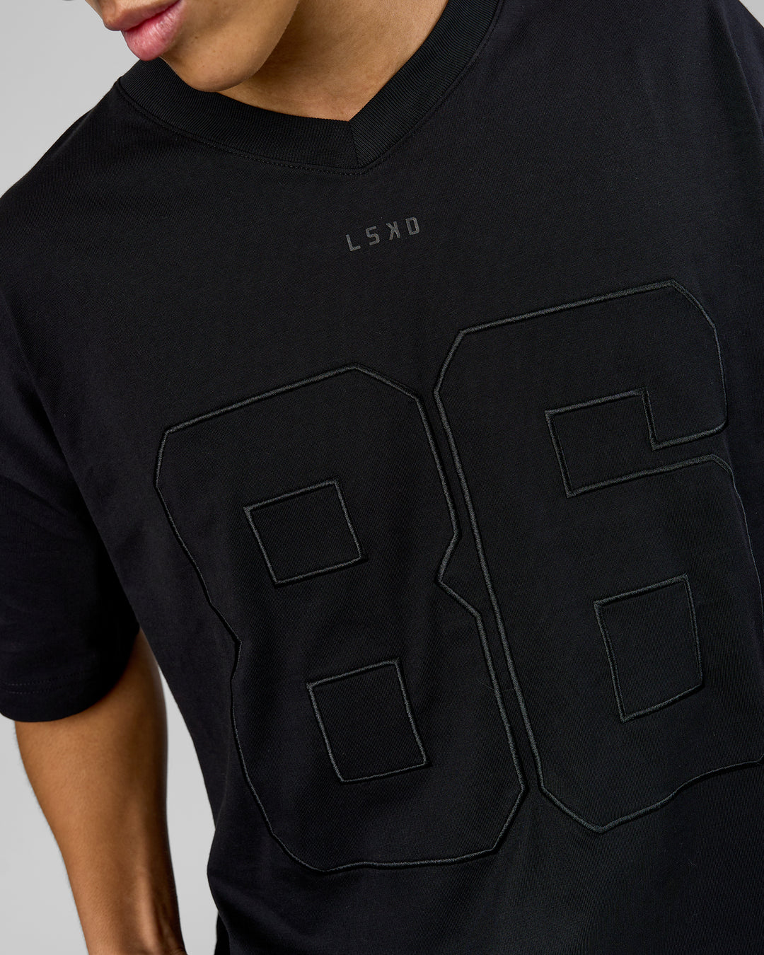 Man wearing 86 V-Neck Oversized Tee - Black-Black | Model:Leandro | Size:M