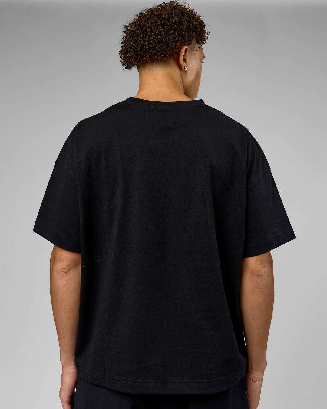 Man wearing 86 V-Neck Oversized Tee - Black-Black | Model:Leandro | Size:M