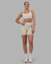 Woman wearing Abs Ignite Sports Bra - Shale Beige-White | Model:Abbey | Size:M