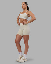 Woman wearing Abs Ignite Sports Bra - Shale Beige-White | Model:Abbey | Size:M