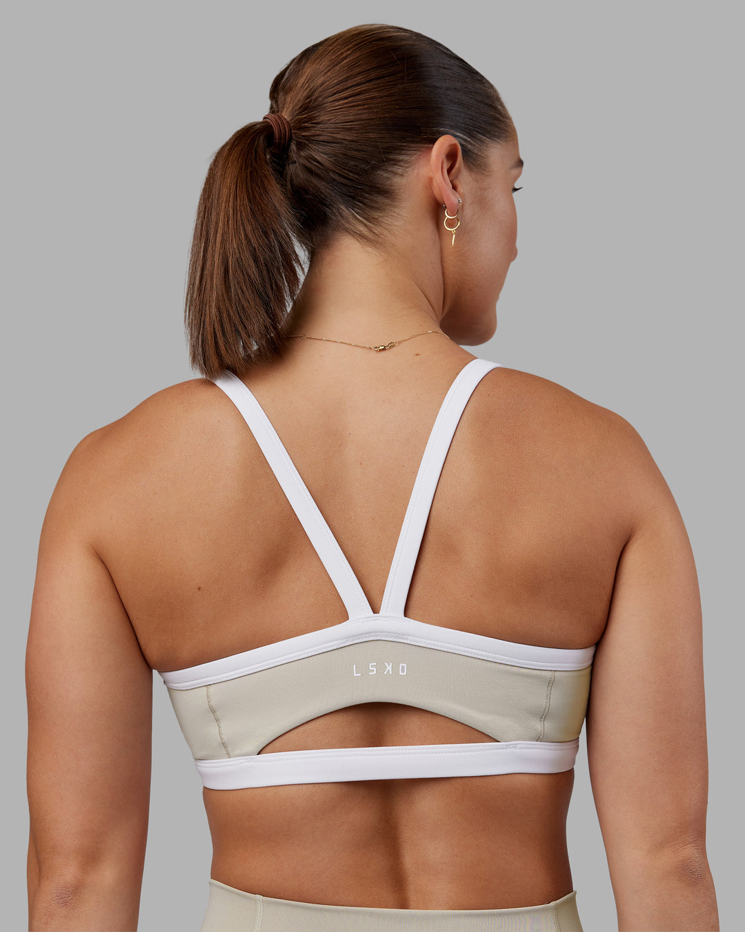 Woman wearing Abs Ignite Sports Bra - Shale Beige-White | Model:Abbey | Size:M