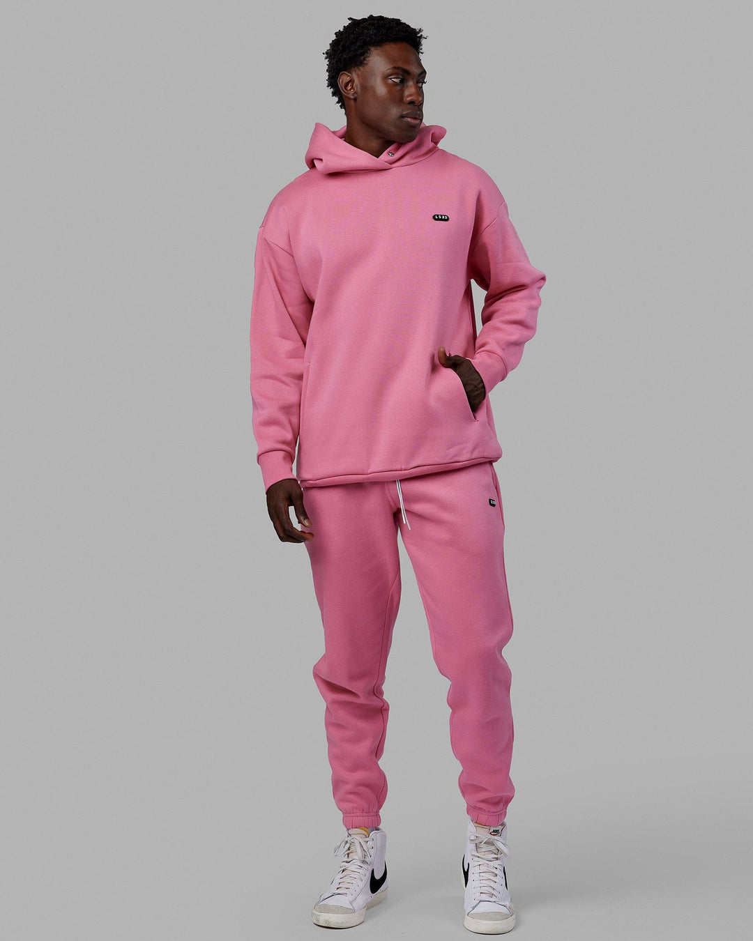 Man wearing Unisex Capsule Hoodie Oversize - Pink Rose