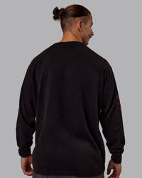 Man wearing Chrome Washed Heavyweight Oversized Long Sleeve Tee - Black-Ultra Orange | Model:Jaiden | Size:M