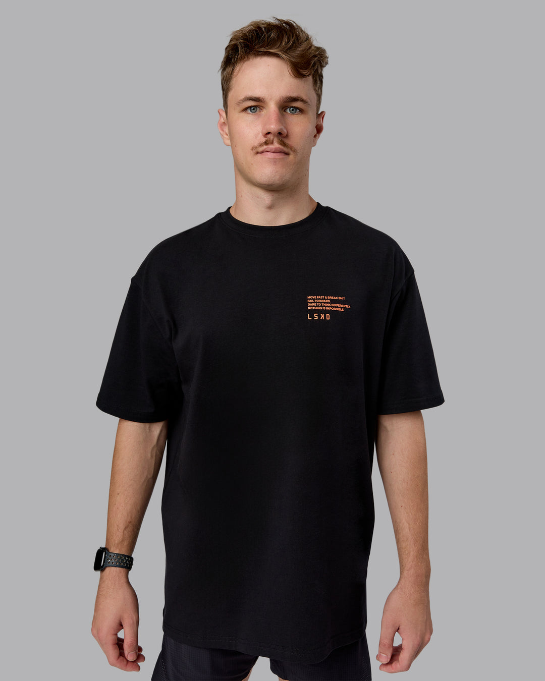 Man wearing Coffee Run FLXCotton Oversized Tee - Black-Ultra Orange | Model:Cameron | Size:M
