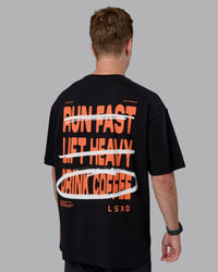Man wearing Coffee Run FLXCotton Oversized Tee - Black-Ultra Orange | Model:Cameron | Size:M