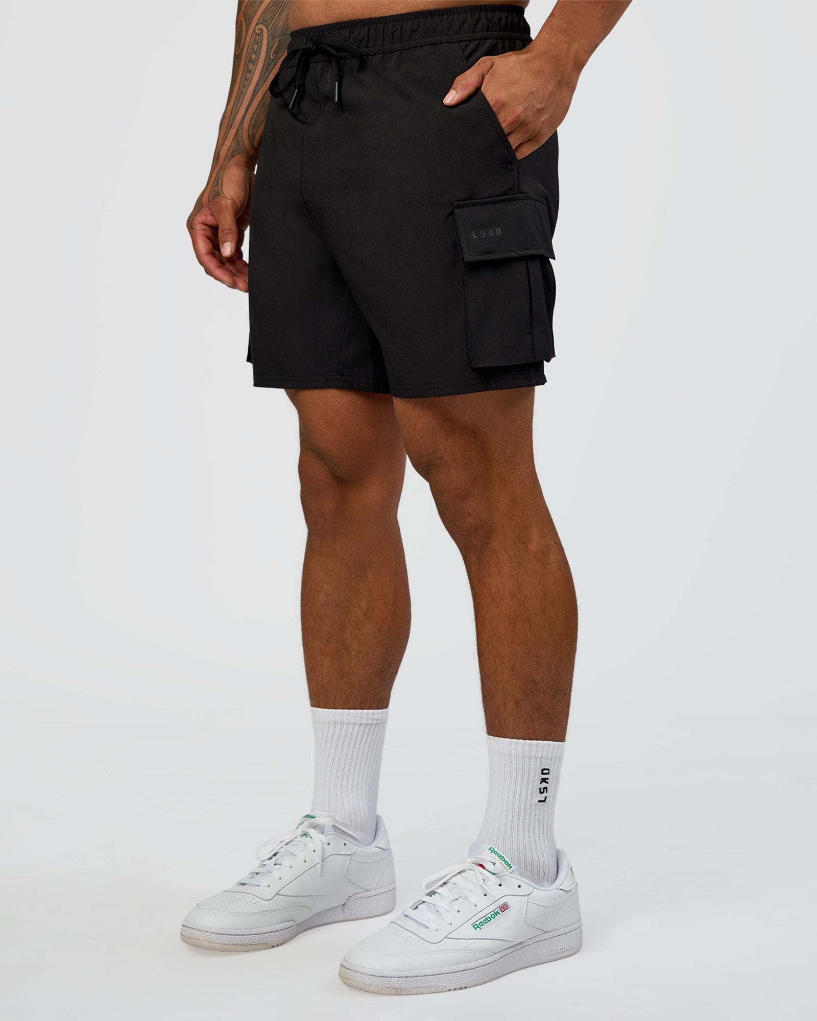Man wearing Energy Stretch 6" Performance Cargo Short - Black | Model:Daarian | Size:M