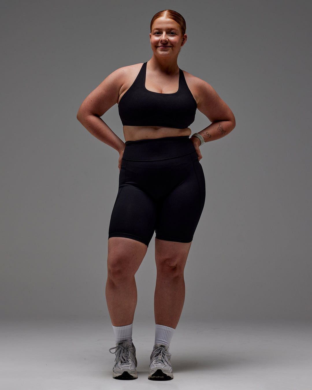 Woman wearing Fusion Ultra High-Rise 9&quot; Short Pockets - Black | Model:Caity | Size:M