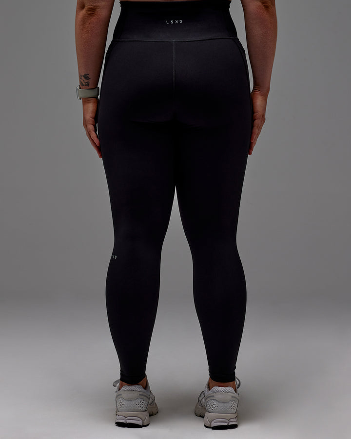 Woman wearing Fusion Full Length Tight With Pockets in Black | Model:Caity | Size:M
