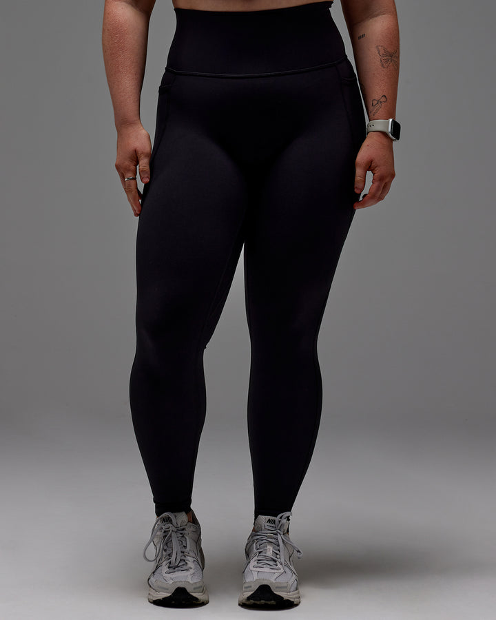 Woman wearing Fusion Full Length Tight With Pockets in Black | Model:Caity | Size:M
