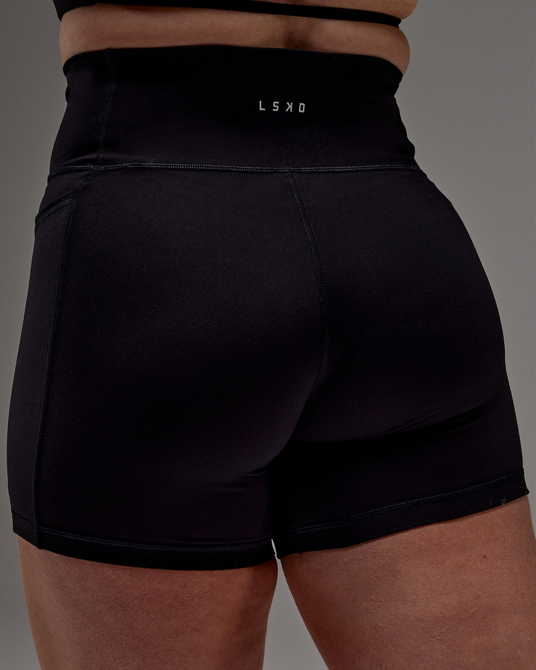Woman wearing Fusion Ultra High-Rise 6&quot; Short Pockets - Black | Model:Caity | Size:M