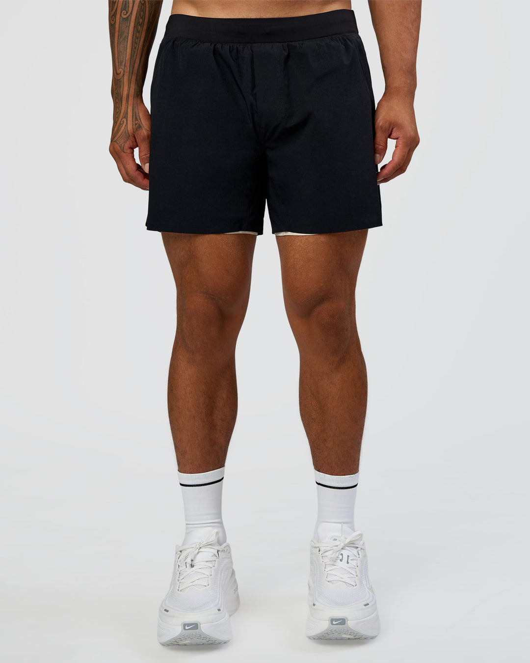 Man wearing Hybrid Lined 5" Short - Black-Shale Beige | Model:Daarian | Size:M