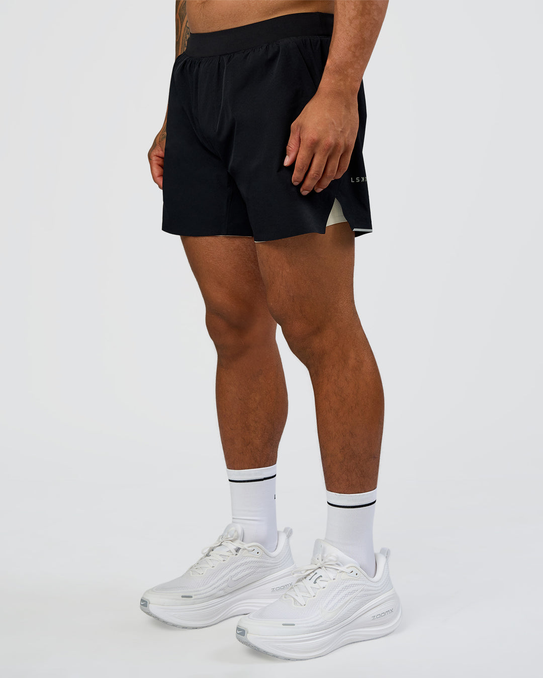 Man wearing Hybrid Lined 5" Short - Black-Shale Beige | Model:Daarian | Size:M