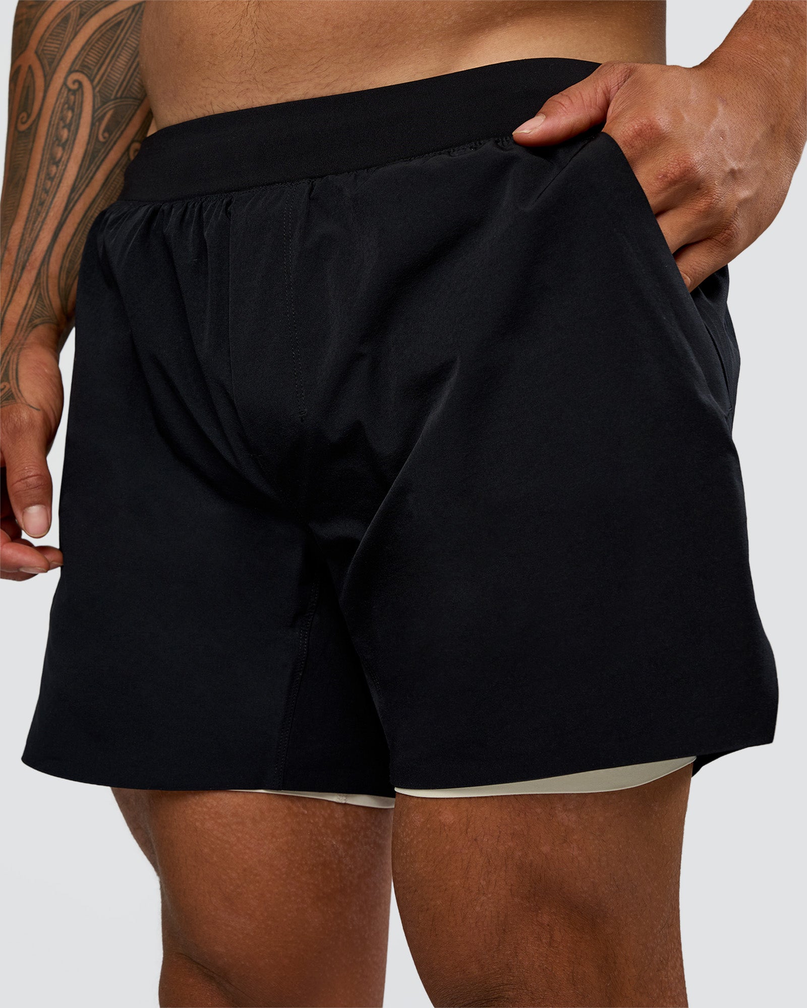 Man wearing Hybrid Lined 5" Short - Black-Shale Beige | Model:Daarian | Size:M