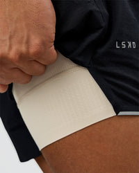 Man wearing Hybrid Lined 5" Short - Black-Shale Beige | Model:Daarian | Size:M