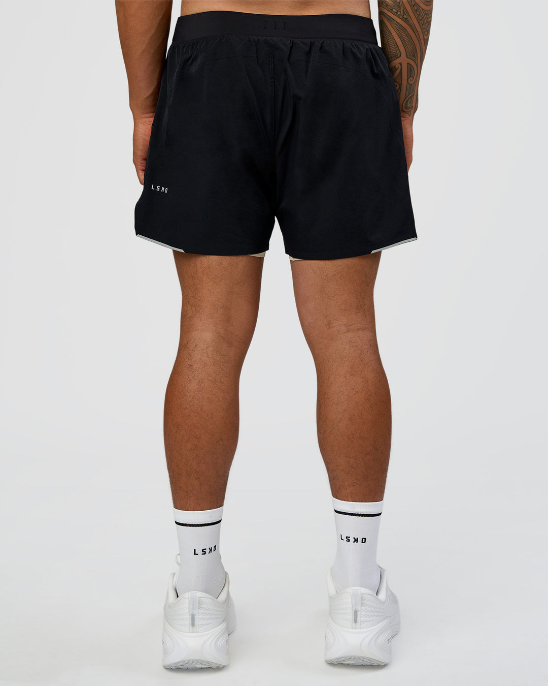 Man wearing Hybrid Lined 5" Short - Black-Shale Beige | Model:Daarian | Size:M