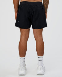 Man wearing Hybrid Lined 5" Short - Black-Shale Beige | Model:Daarian | Size:M