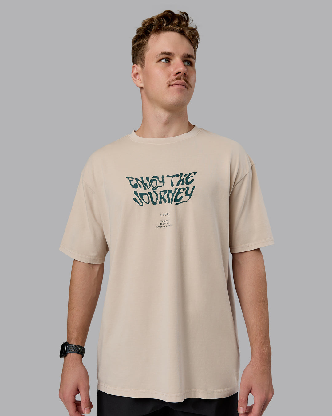 Man wearing Journey FLXCotton Oversized Tee in Washed Shale-Beige Dark-Moss | Model:Cameron | Size:M
