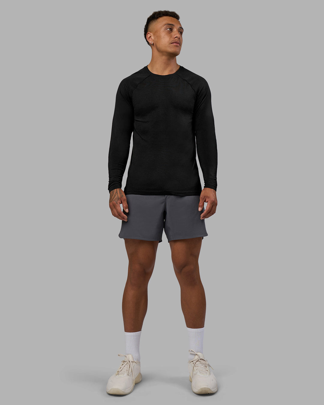 Man wearing AeroFLX+ Seamless Long Sleeve Tee - Black Marl | Model:Daarian | Size:M