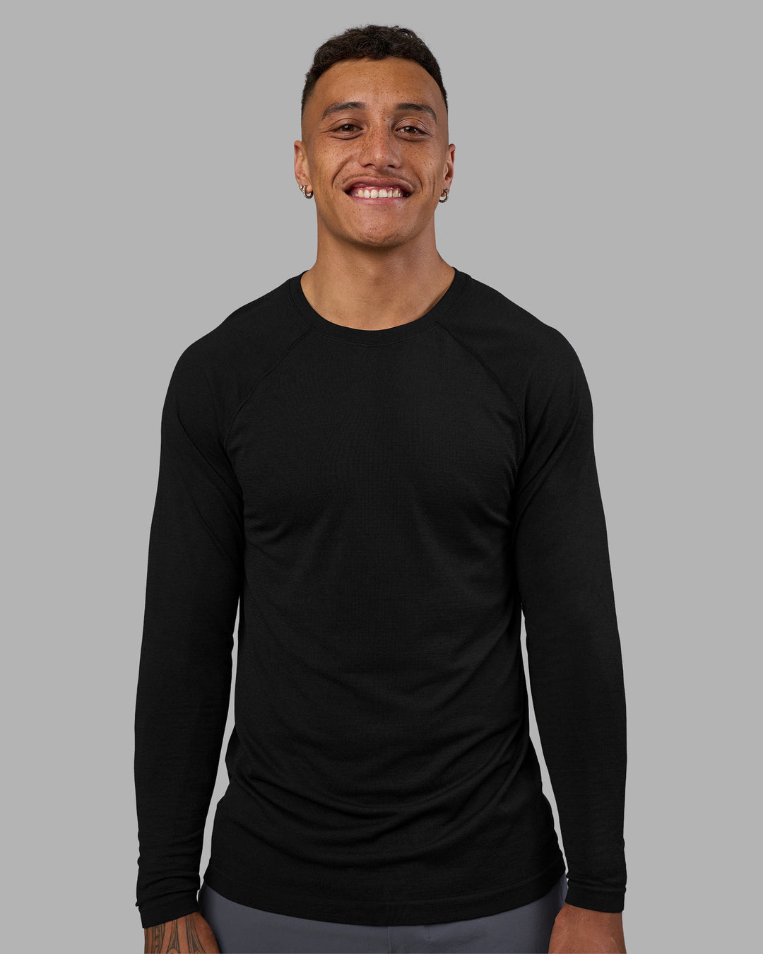 Man wearing AeroFLX+ Seamless Long Sleeve Tee - Black Marl | Model:Daarian | Size:M
