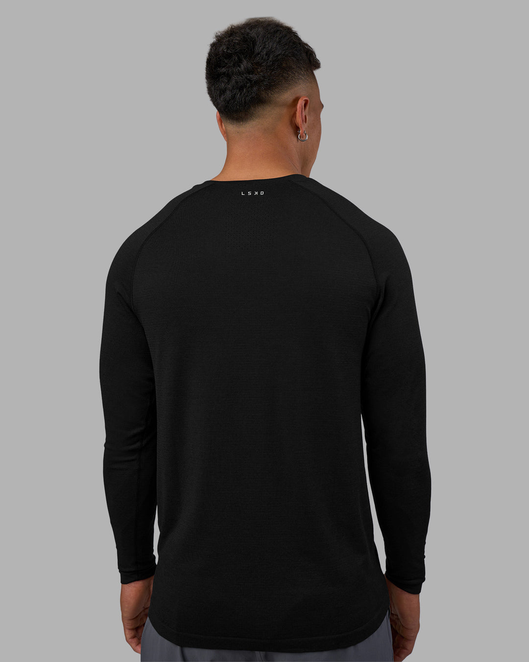 Man wearing AeroFLX+ Seamless Long Sleeve Tee - Black Marl | Model:Daarian | Size:M