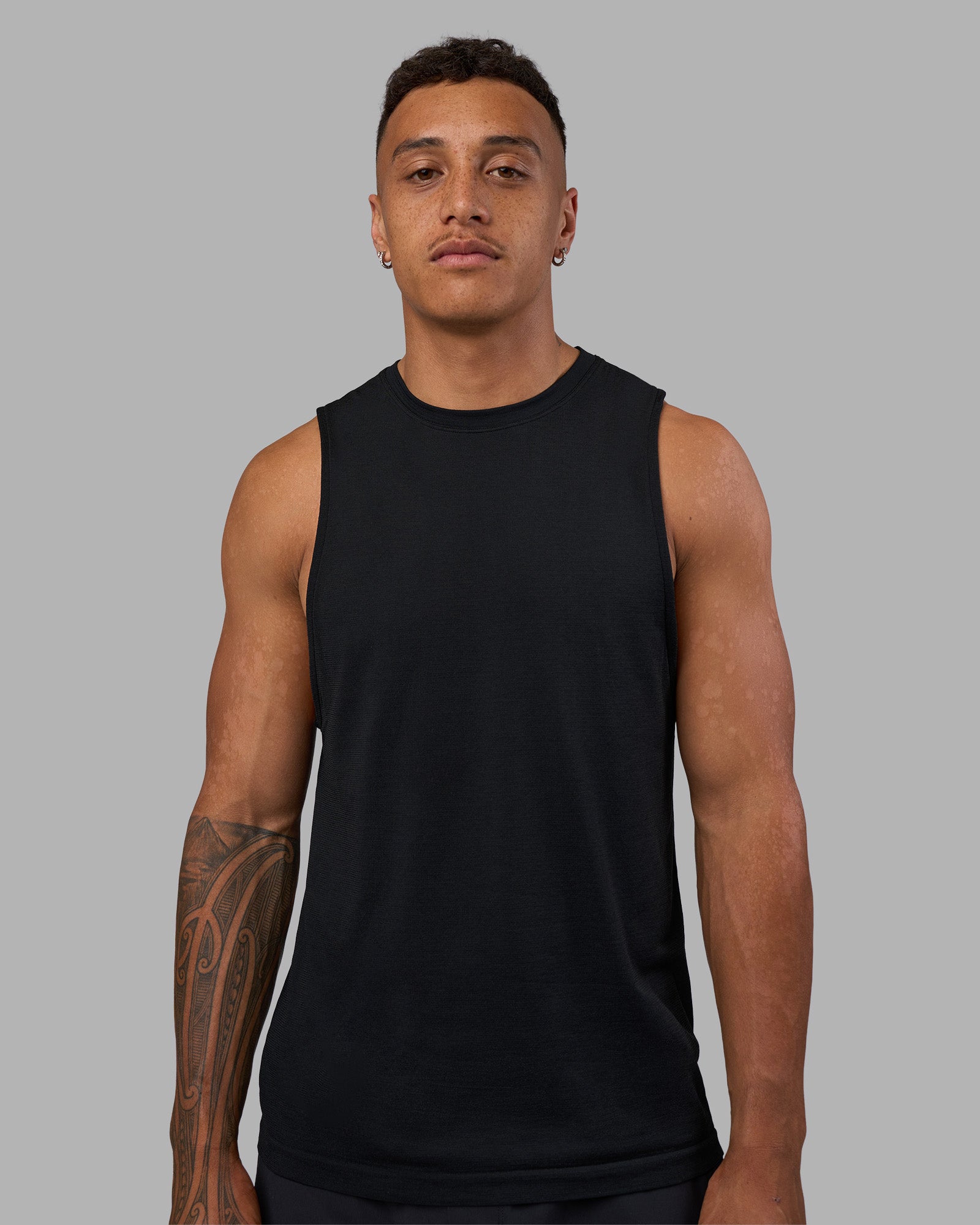 Man wearing AeroFLX+ Seamless Muscle Tank - Black Marl | Model:Daarian | Size:M