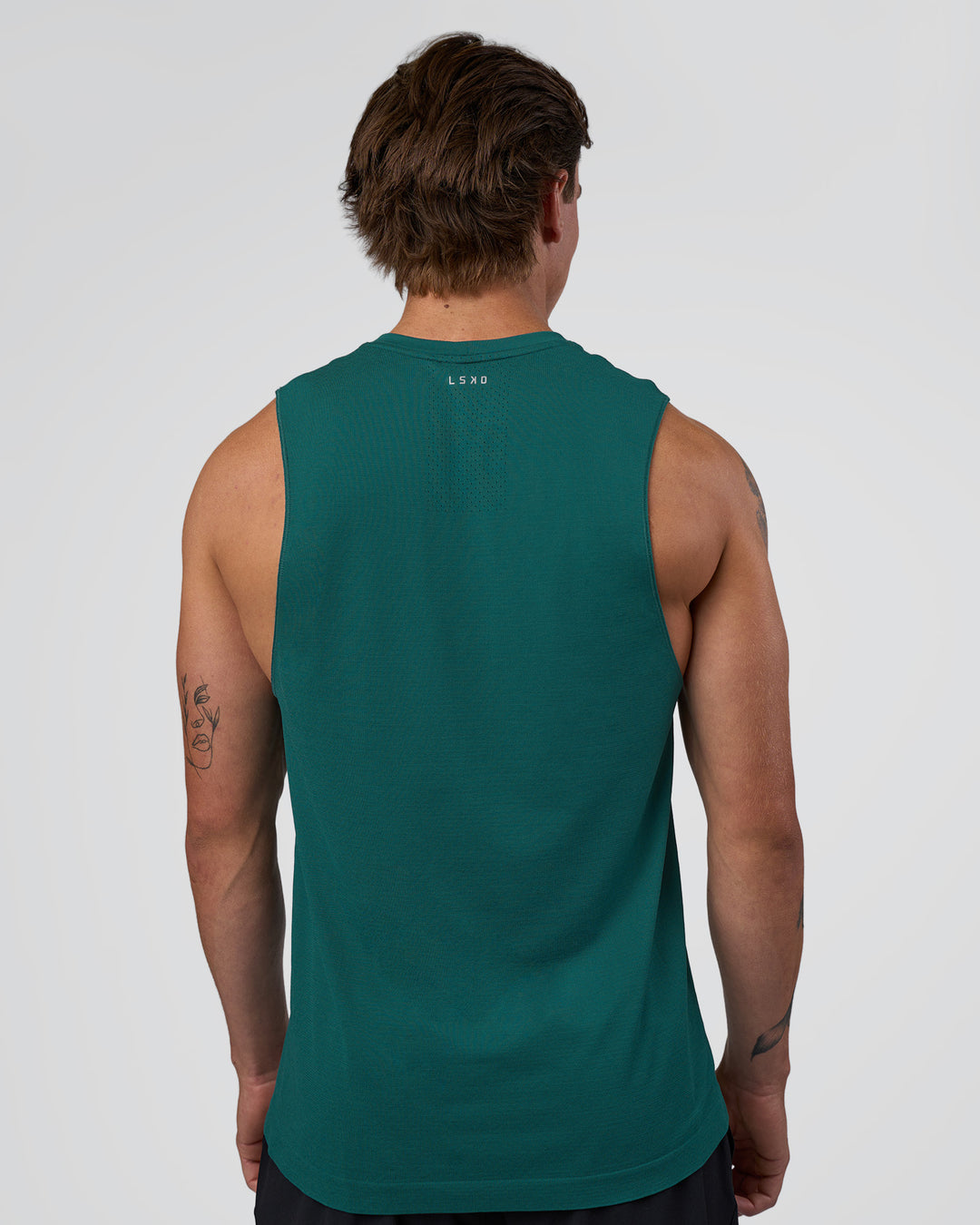Man wearing AeroFLX+ Seamless Muscle Tank - Transformative Teal/Transformative Teal | Model:Konnor | Size:M