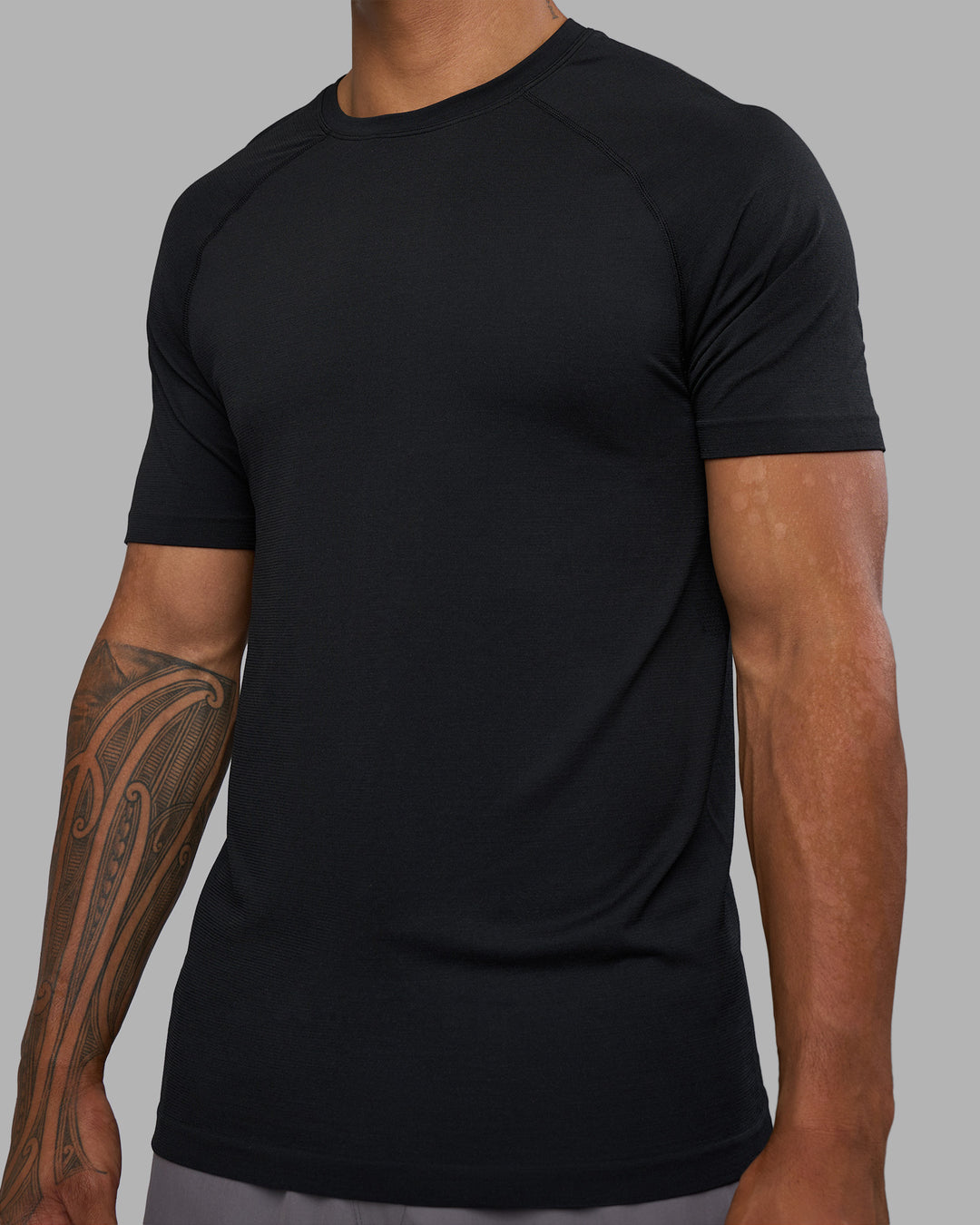 Man wearing AeroFLX+ Seamless Tee - Black Marl | Model:Daarian | Size:M