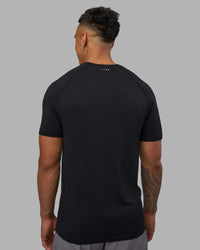 Man wearing AeroFLX+ Seamless Tee - Black Marl | Model:Daarian | Size:M