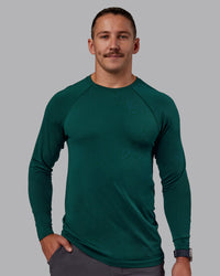Man wearing AeroFLX+ Seamless Long Sleeve Tee - Dark Moss/Dark Moss | Model:Jaiden | Size:M