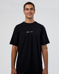 Man wearing Movember 2025 FLXCotton Oversize Tee - Black | Model:Zoran | Size:M