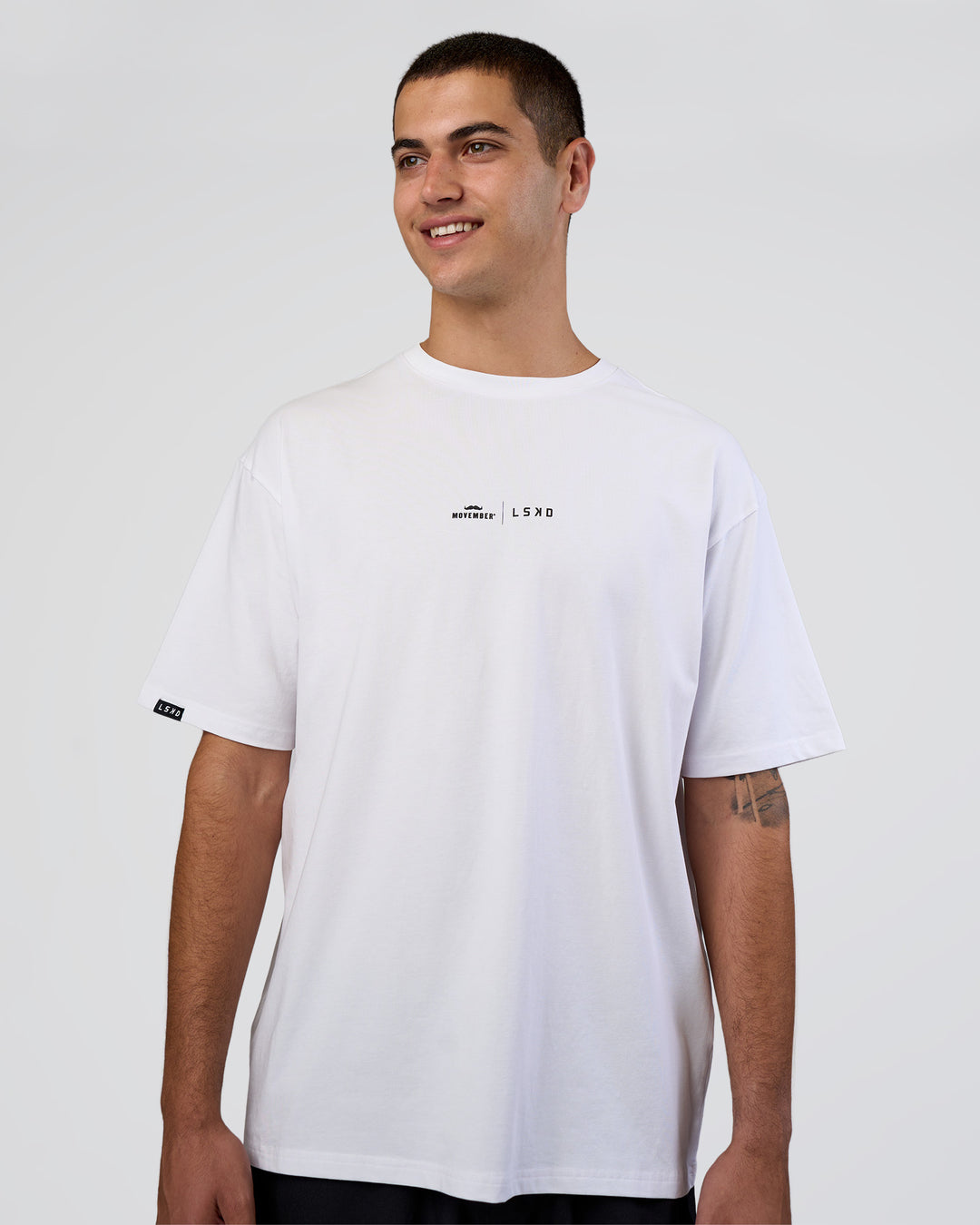 Man wearing Movember 2025 FLXCotton Oversize Tee - White | Model:Zoran | Size:M