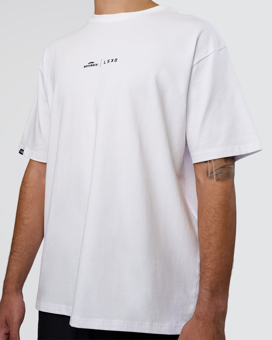 Man wearing Movember 2025 FLXCotton Oversize Tee - White | Model:Zoran | Size:M