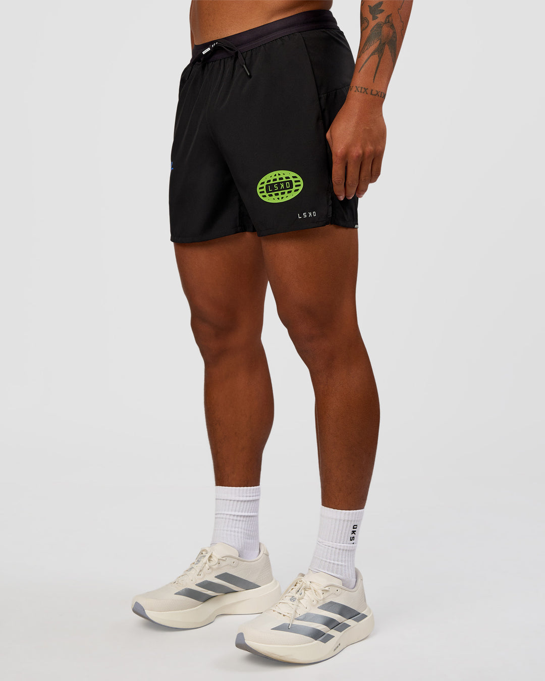 Man wearing Pace 5" Lined Running Short - Black-Lime Glo Indigo | Model:Malebo | Size:M