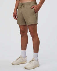 Man wearing Rep 5" Performance Short - Greige | Model:Konnor | Size:M