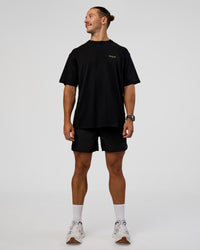 Man wearing RUN CLUB FLXCotton Tee Oversize - Black-Yellow Fizz | Model:Jaiden | Size:M