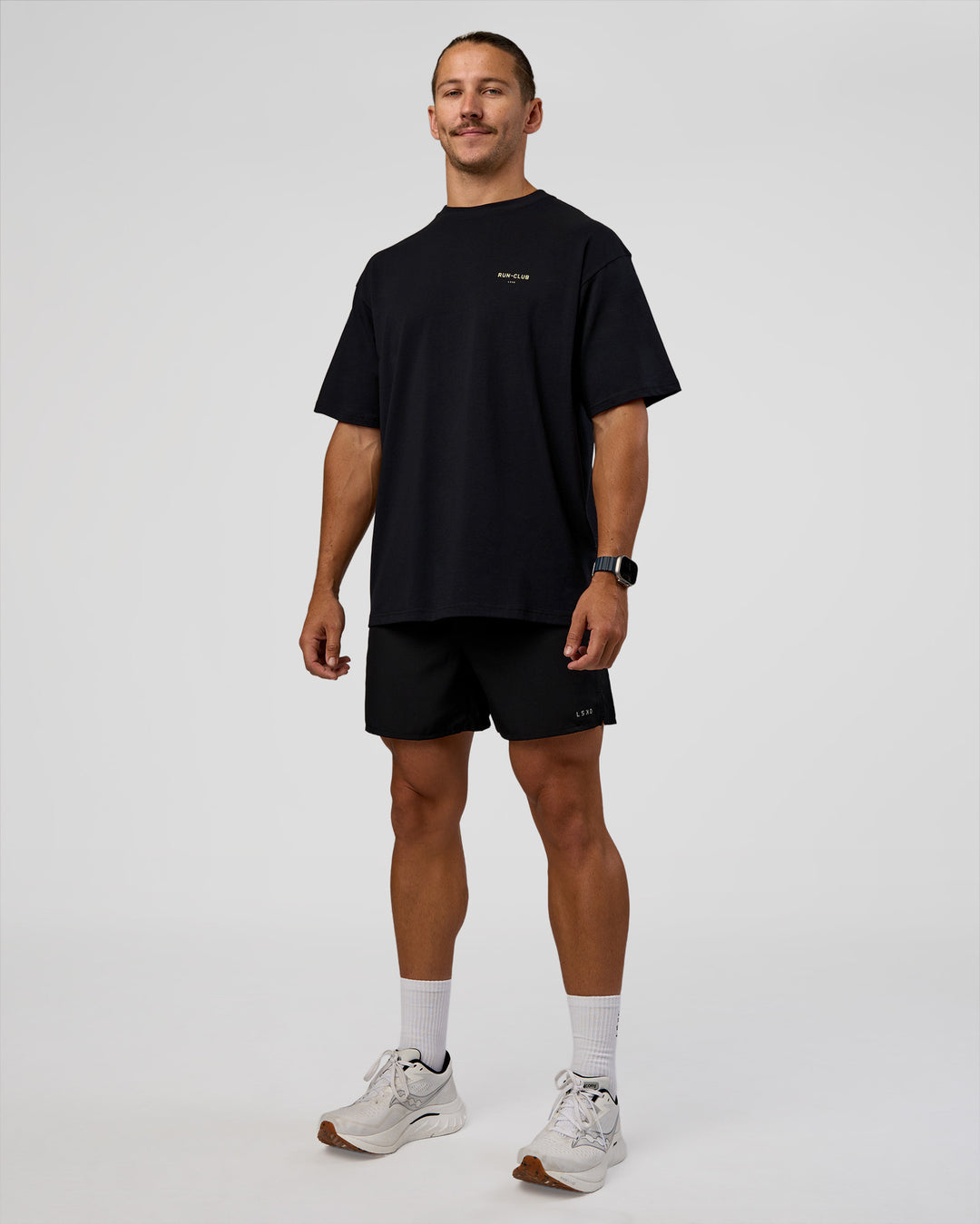 Man wearing RUN CLUB FLXCotton Tee Oversize - Black-Yellow Fizz | Model:Jaiden | Size:M