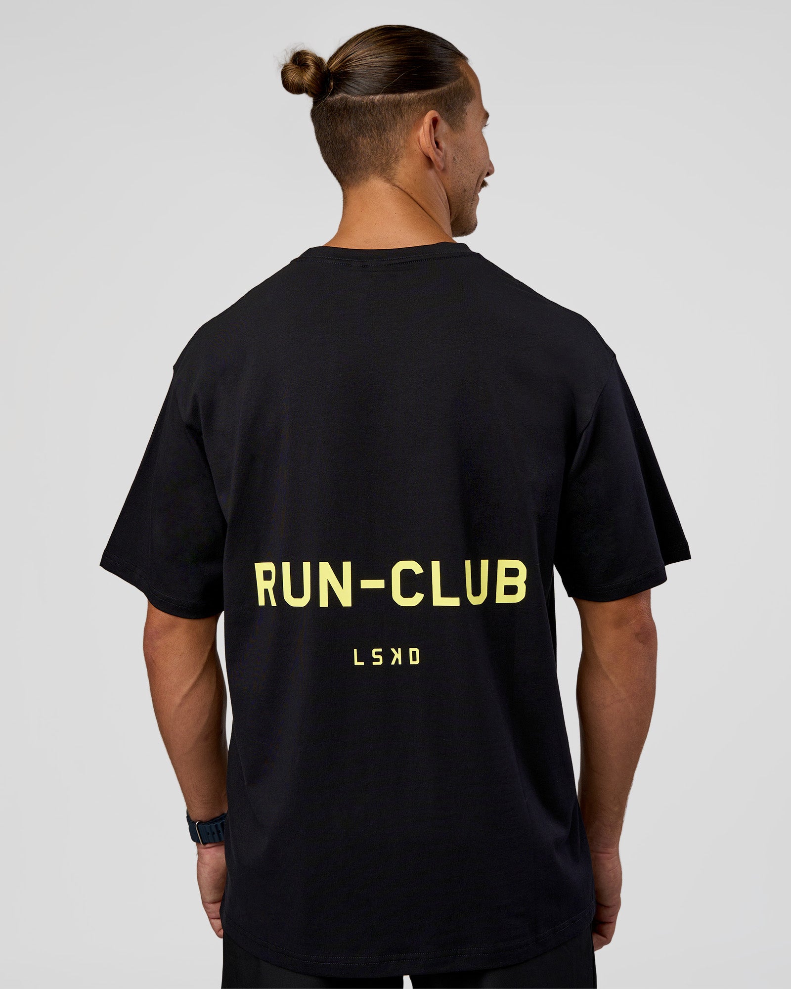 Man wearing RUN CLUB FLXCotton Tee Oversize - Black-Yellow Fizz | Model:Jaiden | Size:M