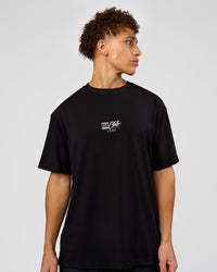 Man wearing Run Club Script FLXCotton Oversized Tee - Black-Alloy | Model:Leandro | Size:M