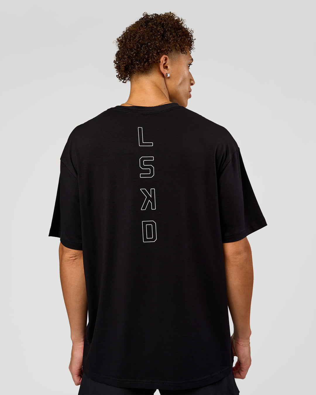 Man wearing Run Club Script FLXCotton Oversized Tee - Black-Alloy | Model:Leandro | Size:M