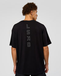 Man wearing Run Club Script FLXCotton Oversized Tee - Black-Alloy | Model:Leandro | Size:M