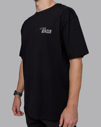 Man wearing Run Love FLXCotton Oversized Tee - Black-Reflective | Model:Cameron | Size:M