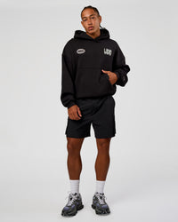 Man wearing Static Grit Unisex Boxy Hoodie - Black-Alloy | Model:Malebo | Size:M