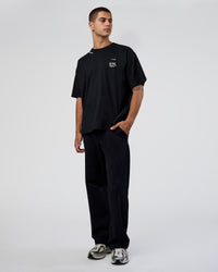 Man wearing Sticker Heavyweight Oversized Tee - Black-White | Model:Zoran | Size:M