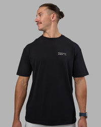 Man wearing Today's Run FLXCotton Oversized Tee - Black-White | Model:Jaiden | Size:M