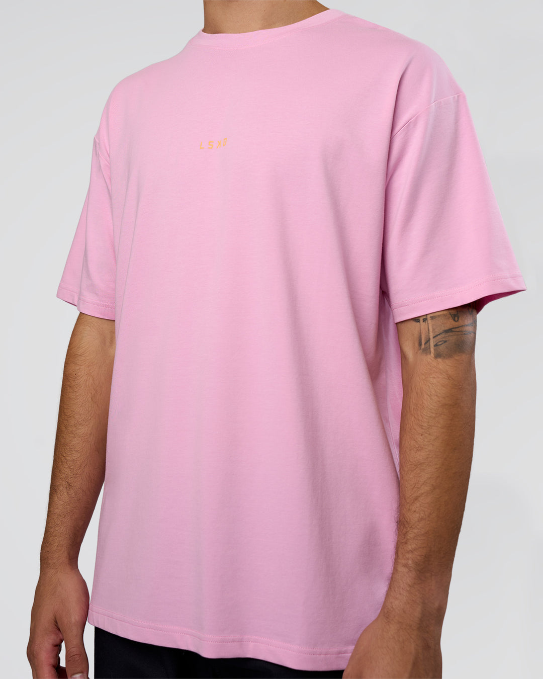 Man wearing Together We Rise FLXCotton Oversized Tee - Bubblegum-Warm Apricot | Model:Zoran | Size:L