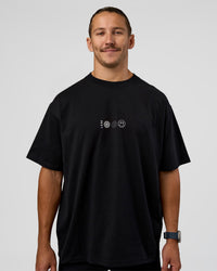 Man wearing Trust The Process Heavyweight Unisex Oversized Tee - Black-White | Model:Jaiden | Size:M