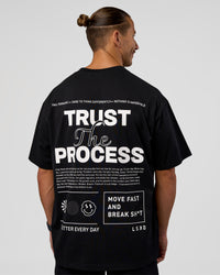 Man wearing Trust The Process Heavyweight Unisex Oversized Tee - Black-White | Model:Jaiden | Size:M