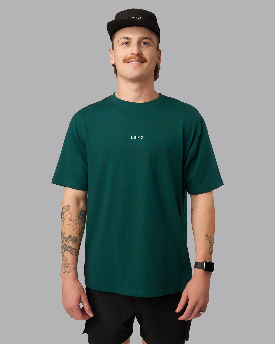 Man wearing On Repeat FLXCotton Oversized Tee - Dark Moss-Ice Green | Model:Isaac | Size:M